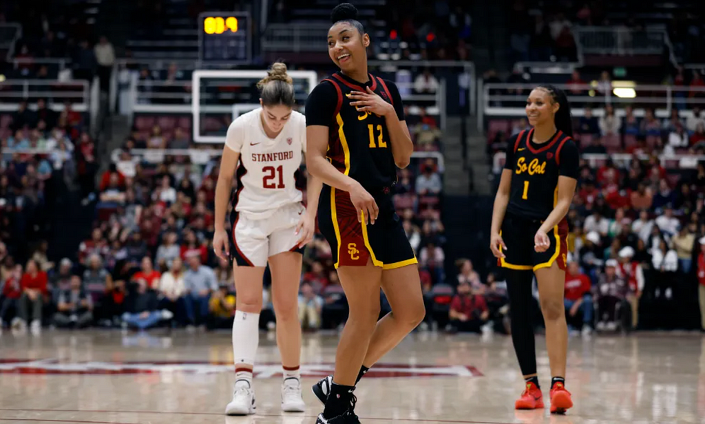 JuJu Watkins laughs while looking off-court during a game between USC and Stanford