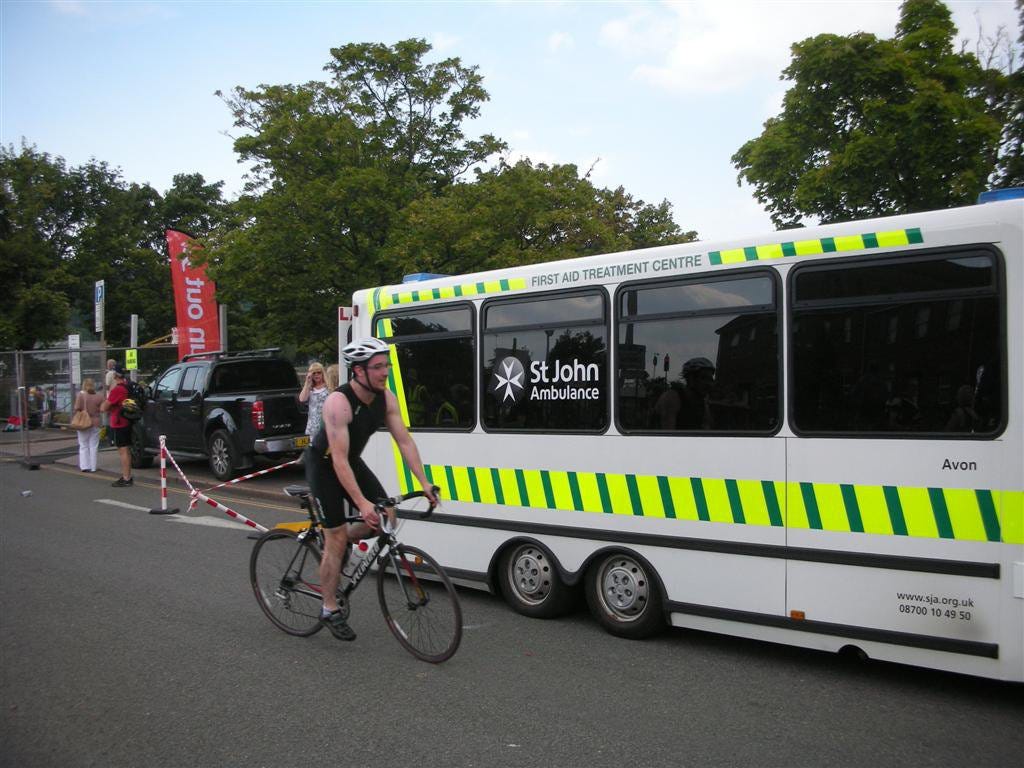 Edward Breen riding a bike beside an ambulance