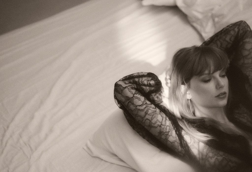 Taylor Swift lying on a bed in black lace for the Tortured Poets photoshoot