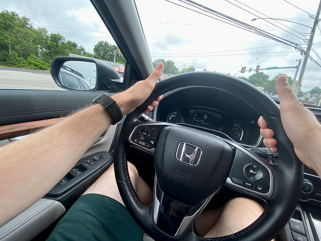 Driving with thumbs up but both hands on the wheel