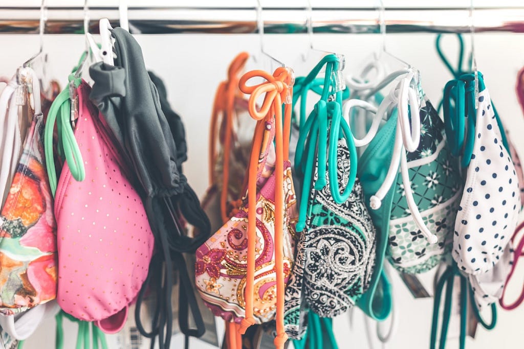 A rack of colorful bikini tops at a swimsuit store.