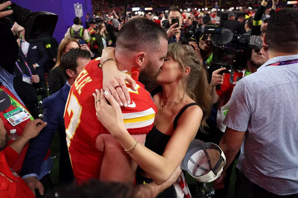 Photo of Taylor Swift and Travis Kelce kissing at the Superbowl.