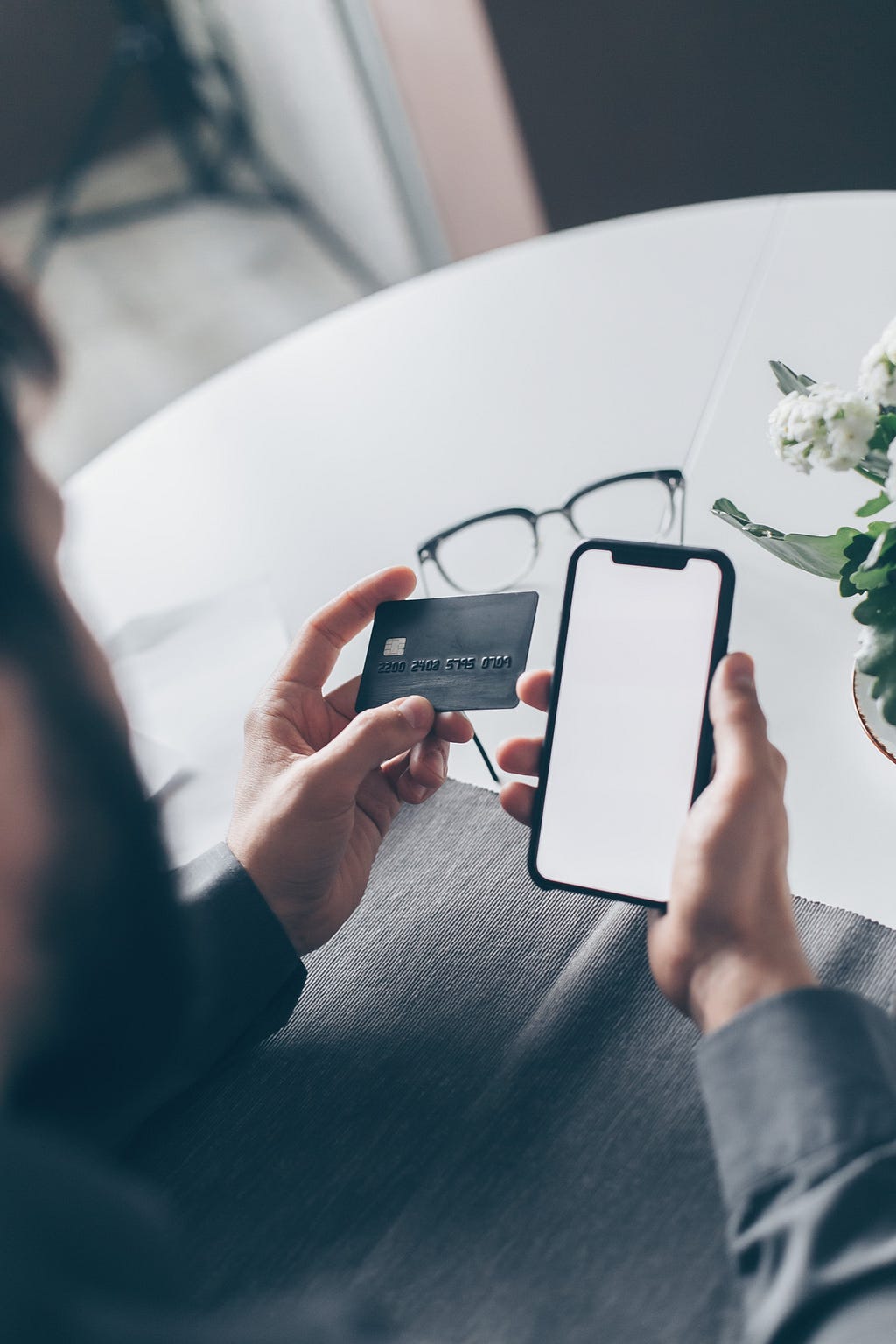 Image of a person holding a cell phone and credit card