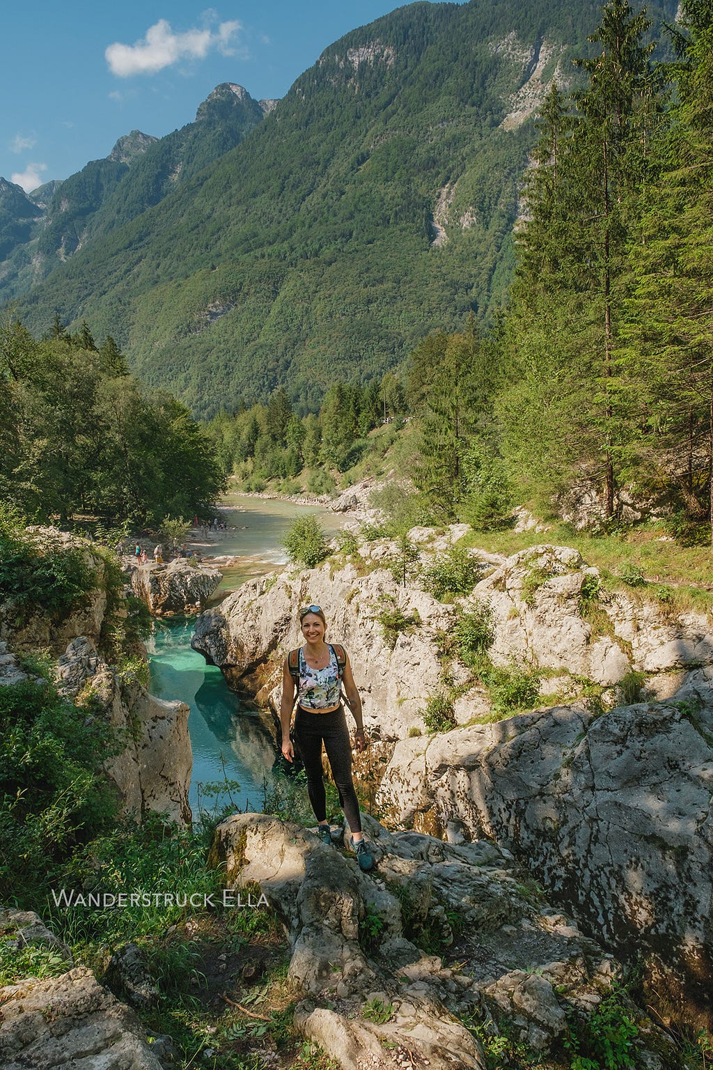 Woman hiking in Slovenia with Soca river and mountains in background