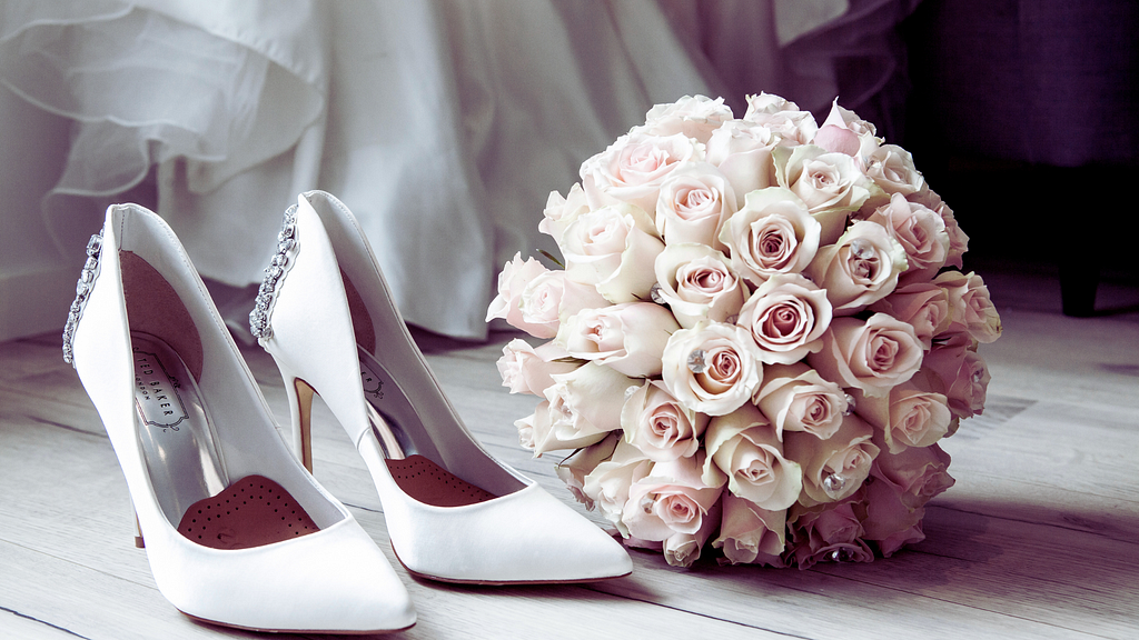 A bouquet of flowers and white wedding shoes