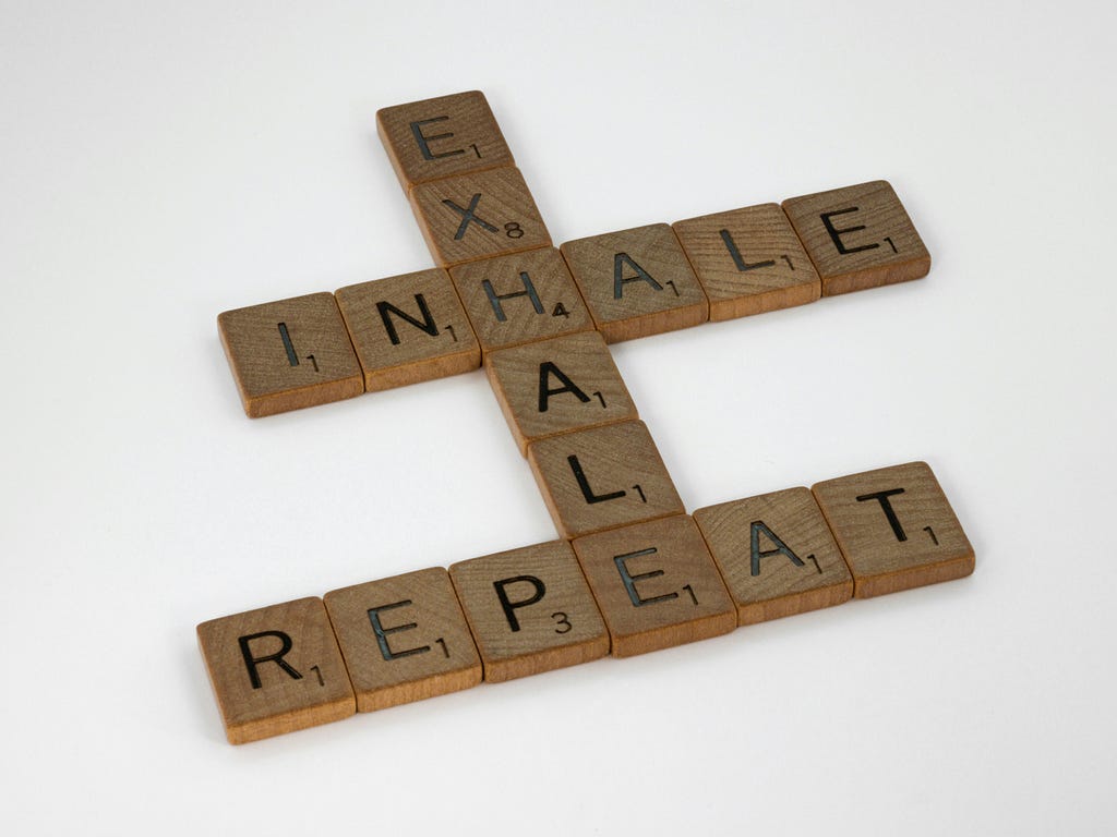 Scrabble blocks that intersect spelling out “inhale, exhale, repeat”