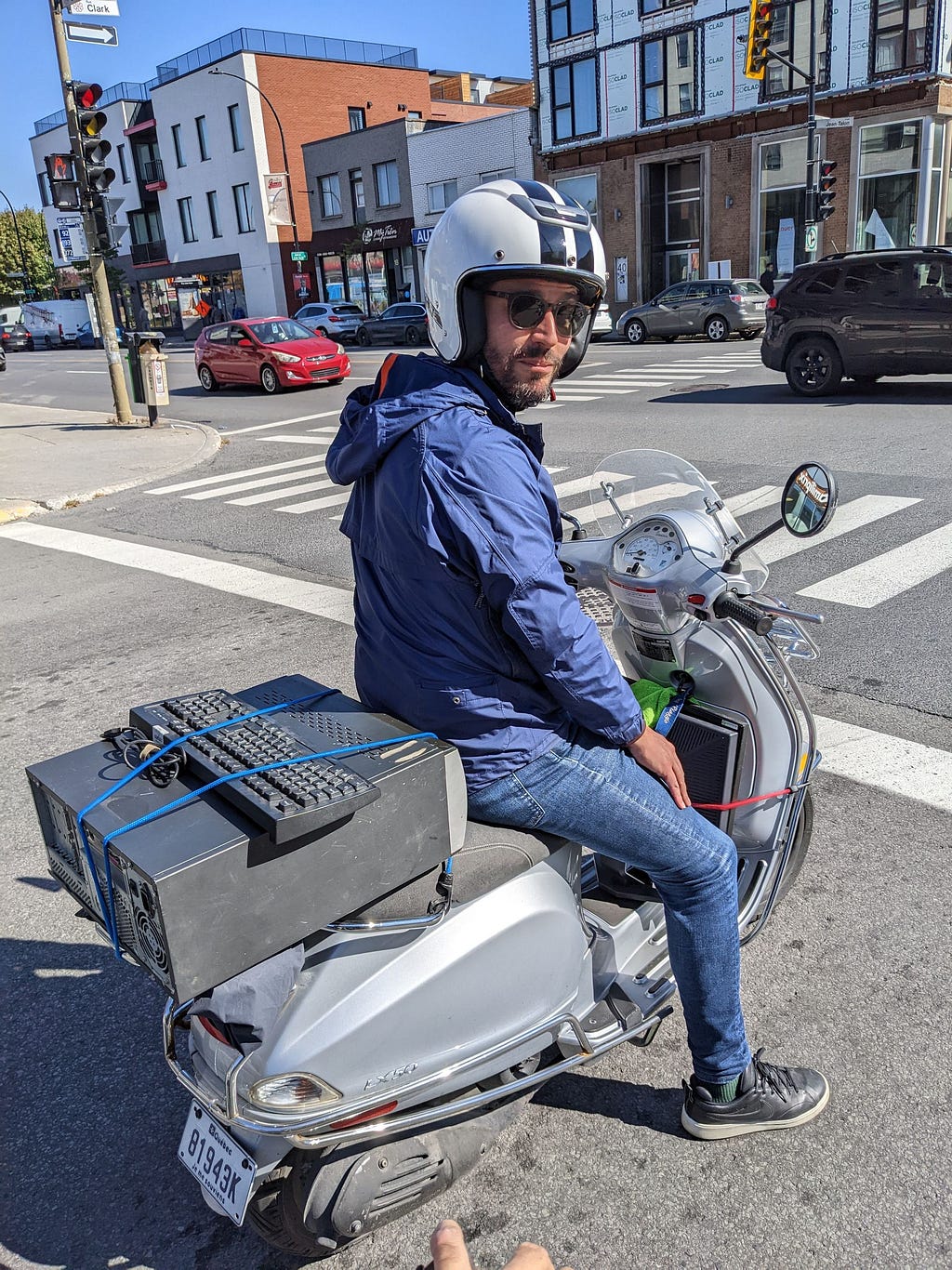 Mathieu ramène un vieux PC sur son scooter.