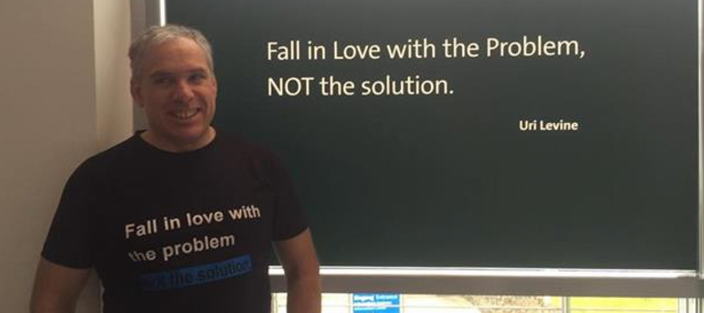 Na imagem vemos Uri Levine, criador do Waze, um homem branco com cabelos grisalhos e lemos a frase em inglês: “Apaixone-se pelo problema, não pela solução.”