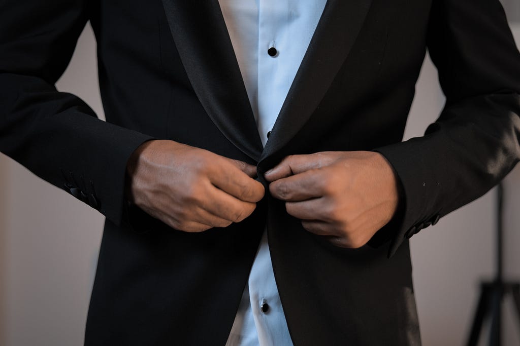 businessman-buttoning-up-blazer-of-elegant-suit