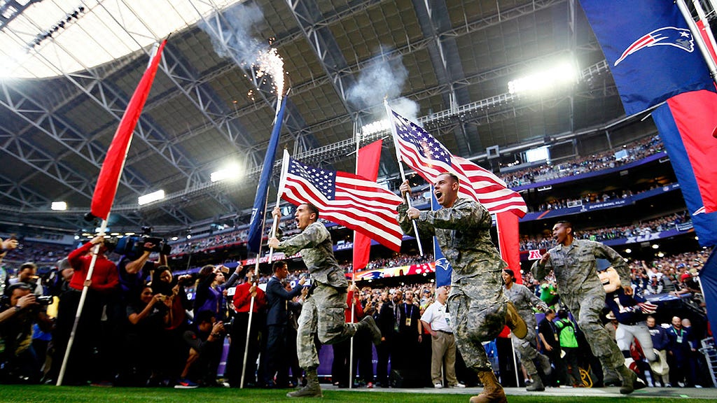 Members of the United States military run onto the field prior to Super Bowl XLIX between the Seattle and New England.