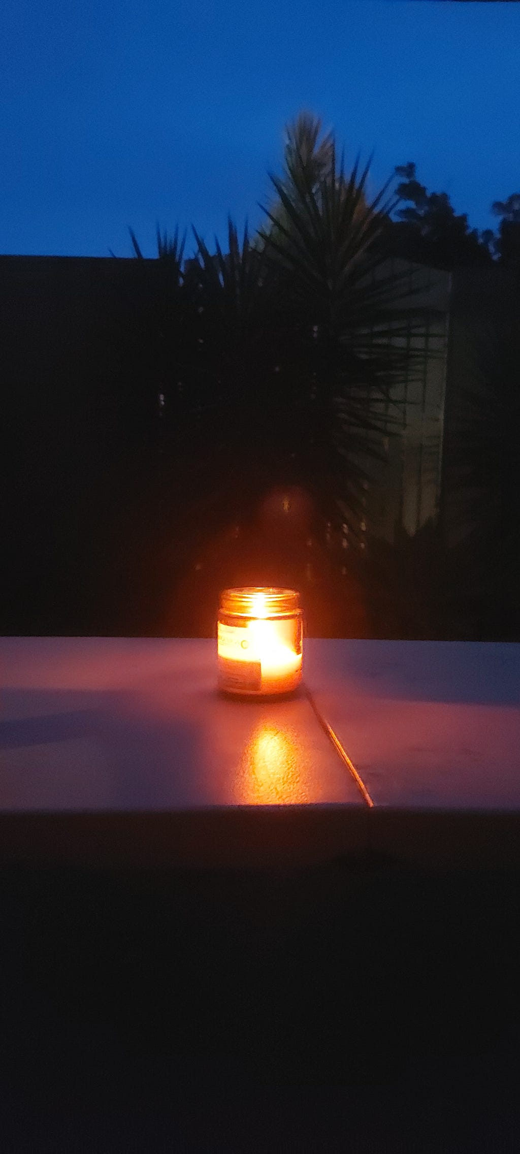 A lit candle outside the house