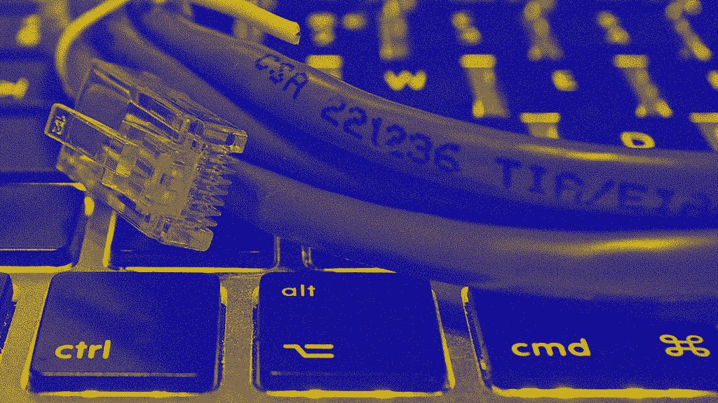 An ethernet cable resting on a MacBook keyboard.