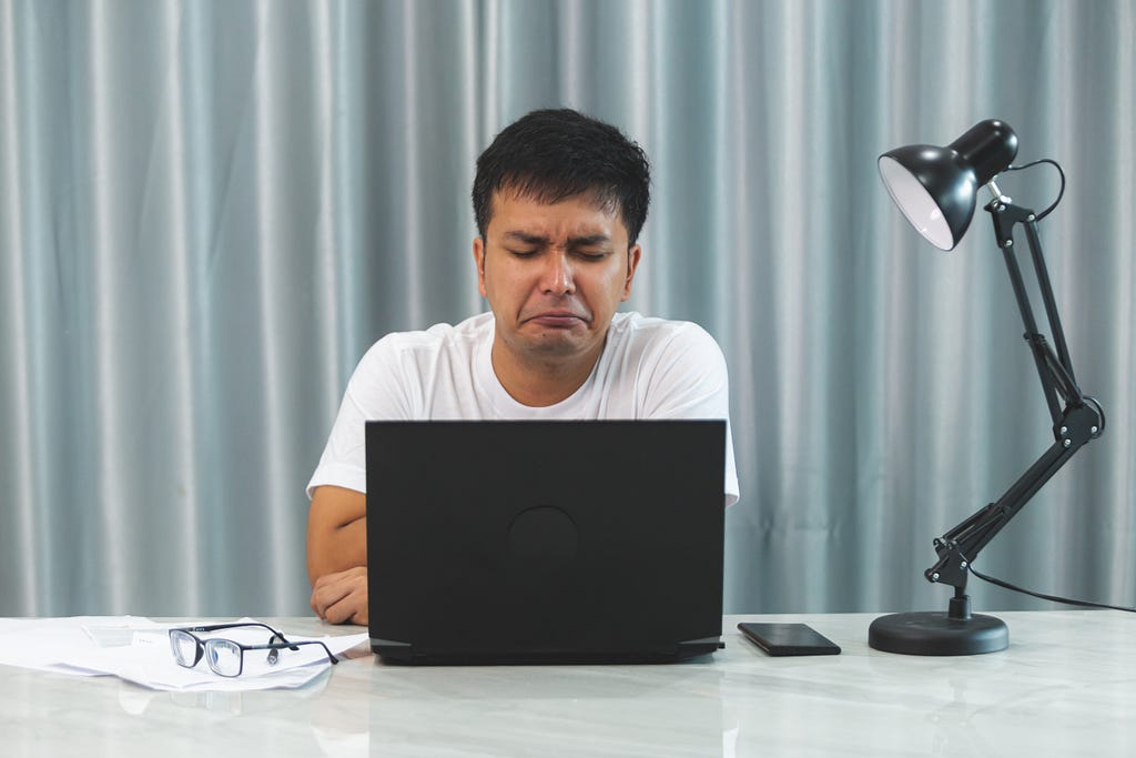 A frustrated man staring at his computer screen.