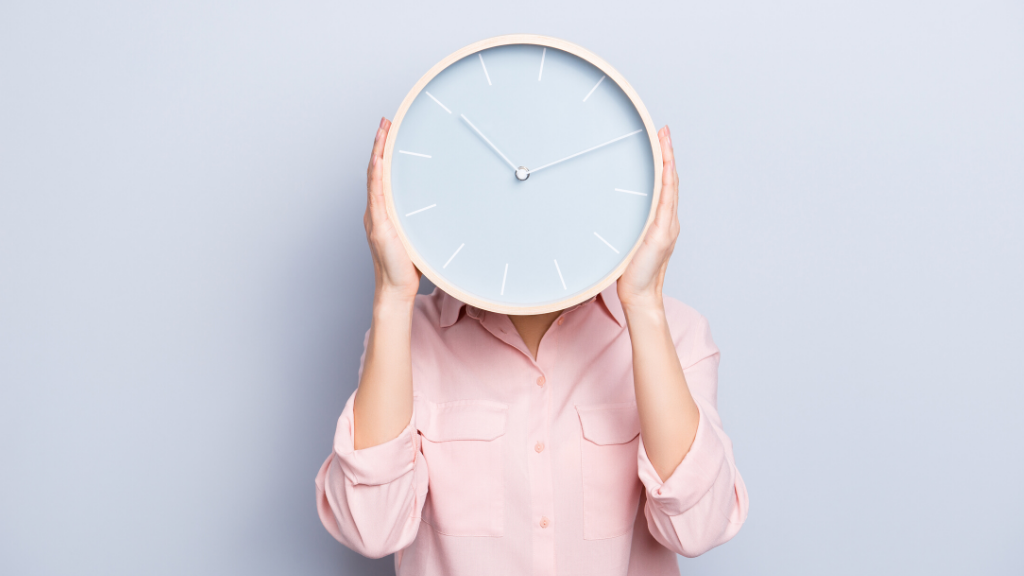 Time Management: A women holding a clock in front of her face