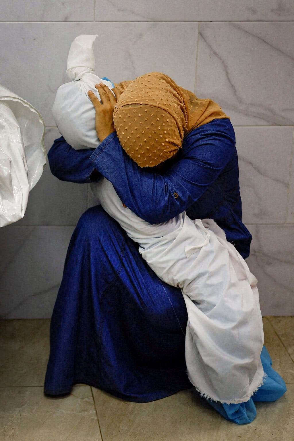 A grieving mother holds her dead child.
