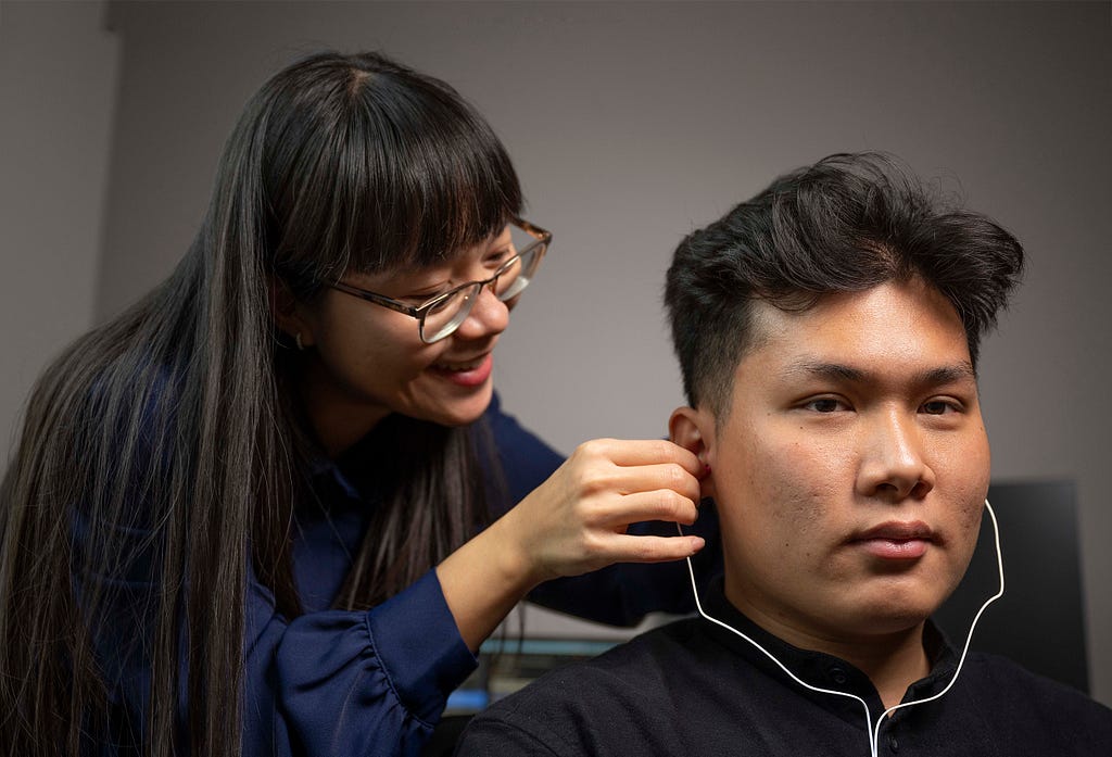 Anh Nguyen adjusts equipment for a research subject.