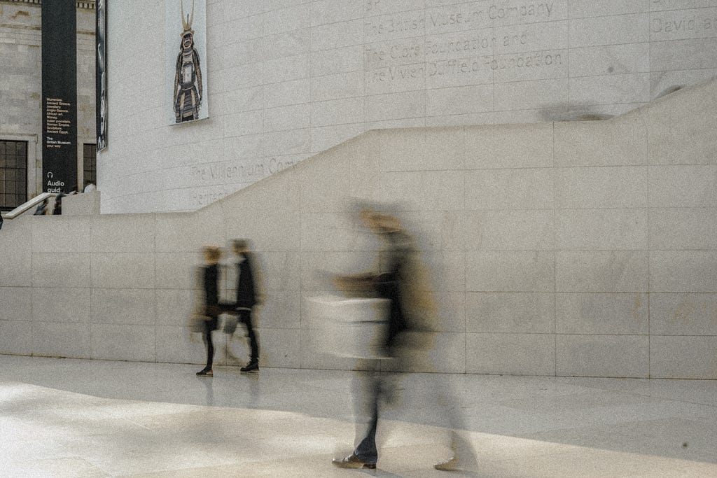 People walking in the British Museum. The moving people are blurred.