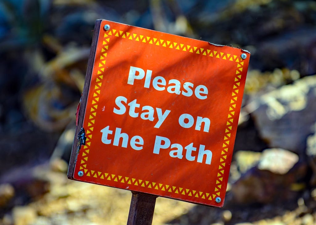 A Please Stay On The Path sign
