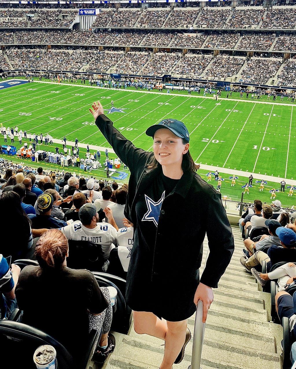 The writer posing from the stands with the AT&T Stadium NFL field behind.