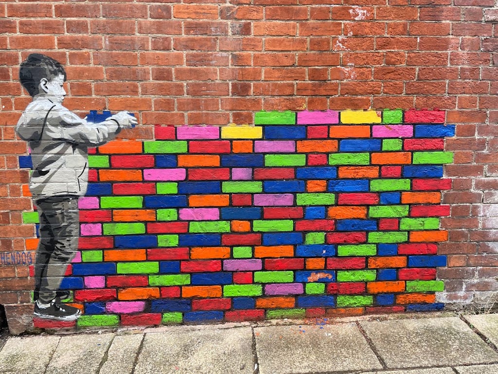 Belinda Fewings took this photo of graffiti on a wall depicting a boy piling colorful blocks.