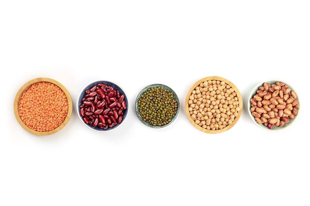 Five bowls, each containing a different type of bean.
