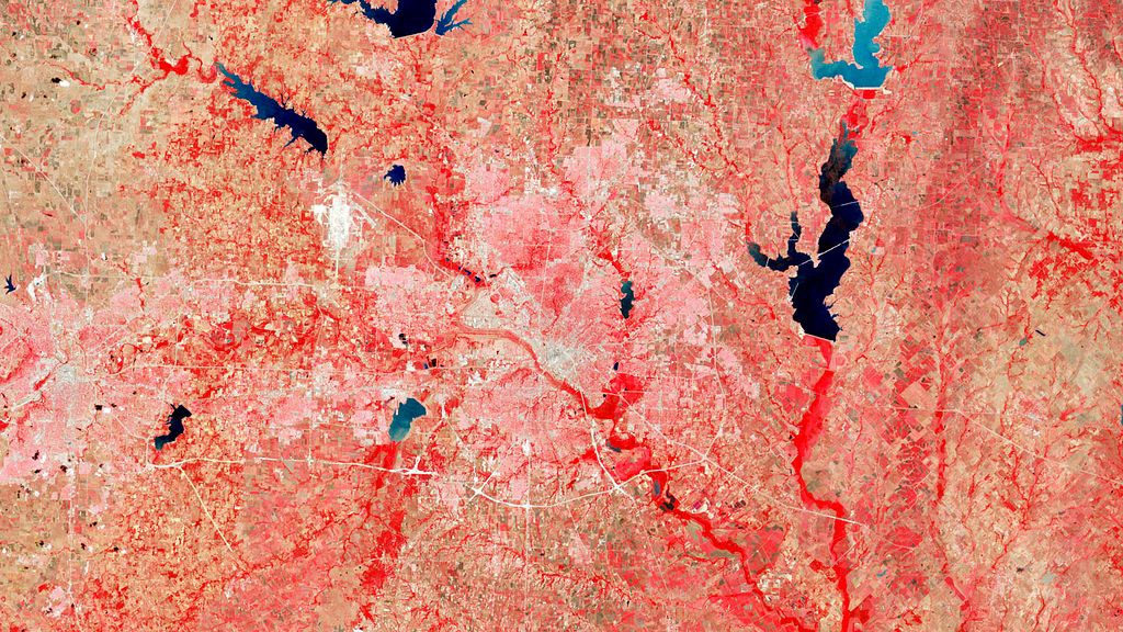 False-color satellite image of Dallas, Texas collected on May 16, 1987. Vegetated fields, forests, and woods are bright red, fallow fields are brown, urban areas are gray, and water is blue or dark blue-black, depending on the amount of sediment.