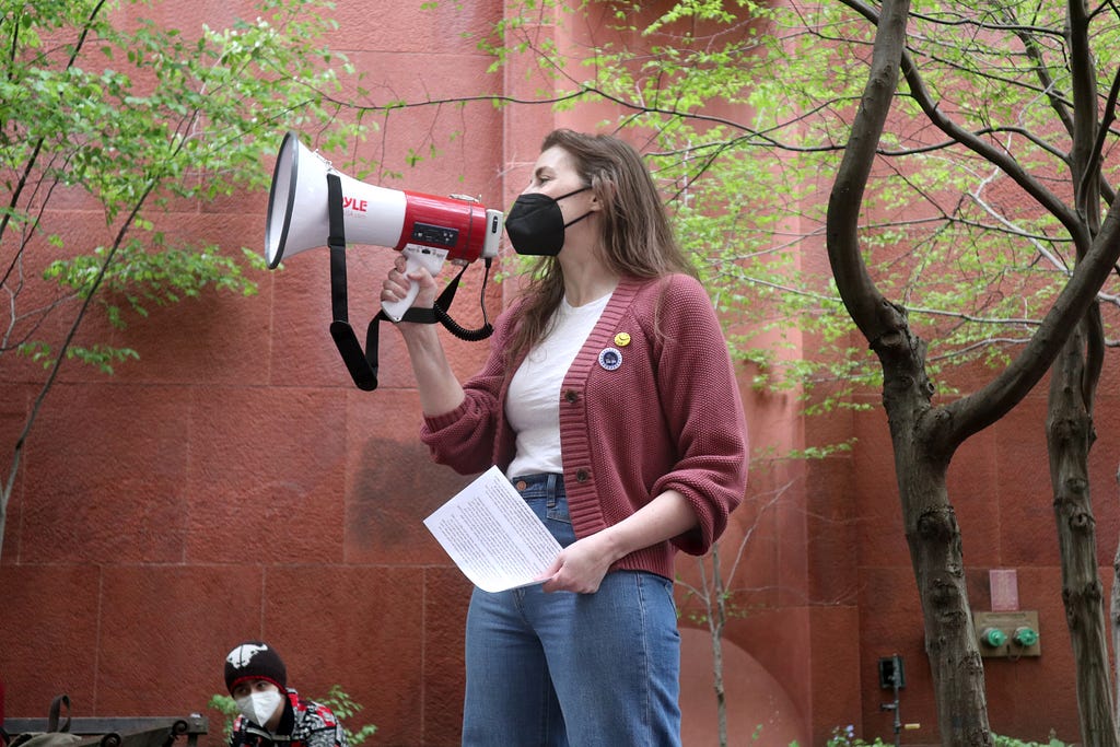 Elisabeth Fay speaks into a megaphone to address the crowd.