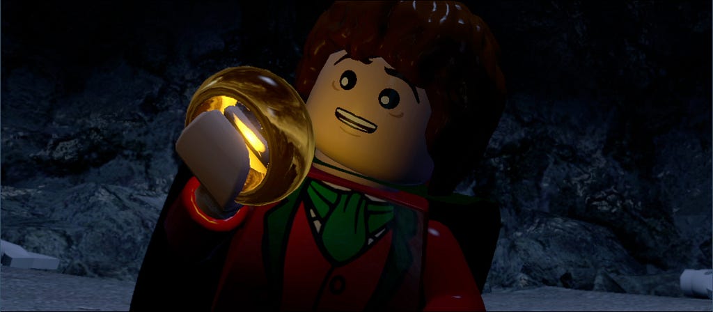 Personaje de Lego de “El señor de los Anillos” (posiblemente Frodo) admirando el poder del anillo. Tiene una expresión de miedo, asombro y deseo. ¡Muchacho! Ahora solo tienes que saber qué hacer con él.