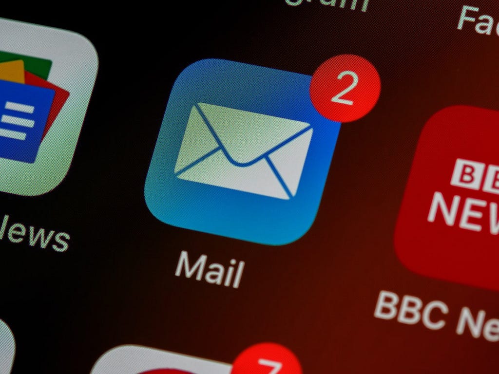 A smartphone screen with several apps displayed, including the “Mail” app. The Mail app has two red notifications, indicating that there are new emails waiting to be read.