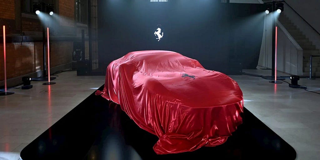 A mystery Ferrari with red cloth over it.