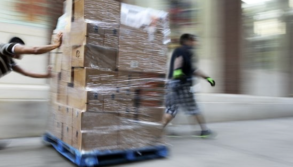 Workers moving boxes in warehouse.