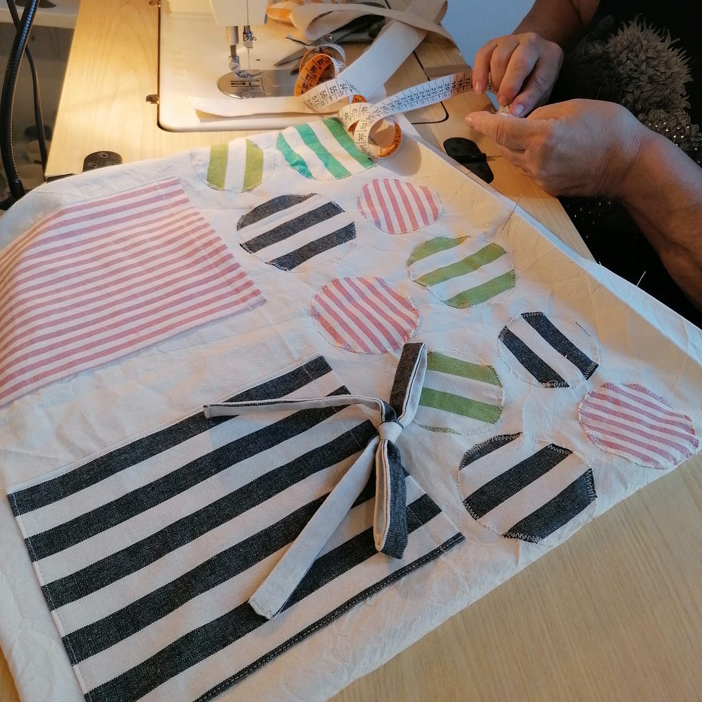 Anne Marie al lavoro con una shopper decorata con tessuti di recupero (thanks to Madam, you have a project)