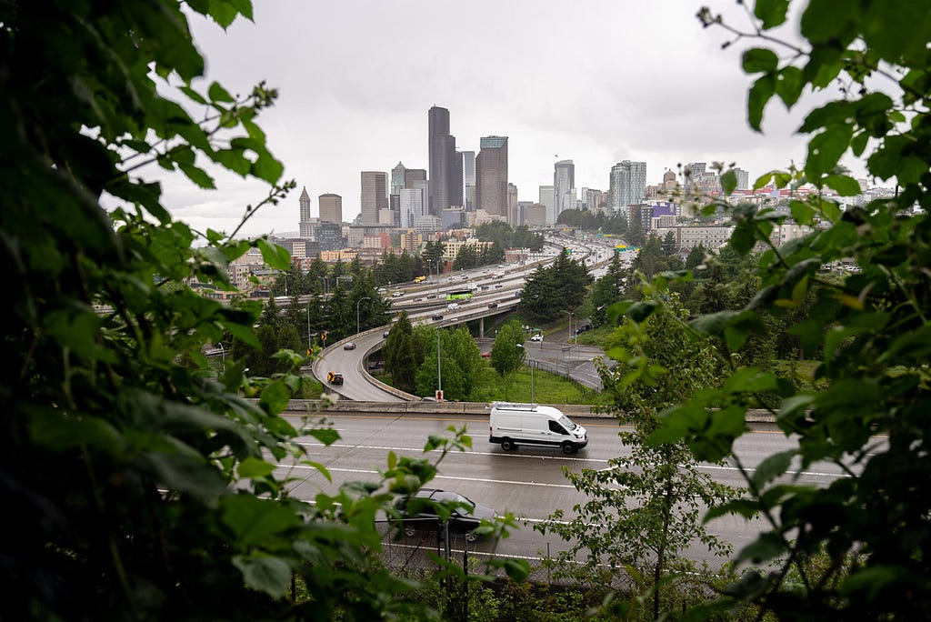 The Seattle skyline on a cloudy day with highways in the foreground.