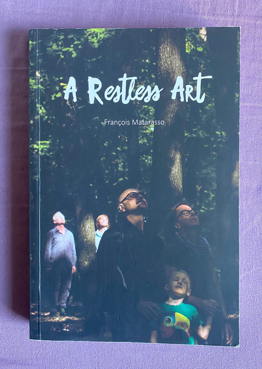 Cover of book A Restless Art by François Matarasso, showing a group of people outdoors looking upwards, surrounded by trees.