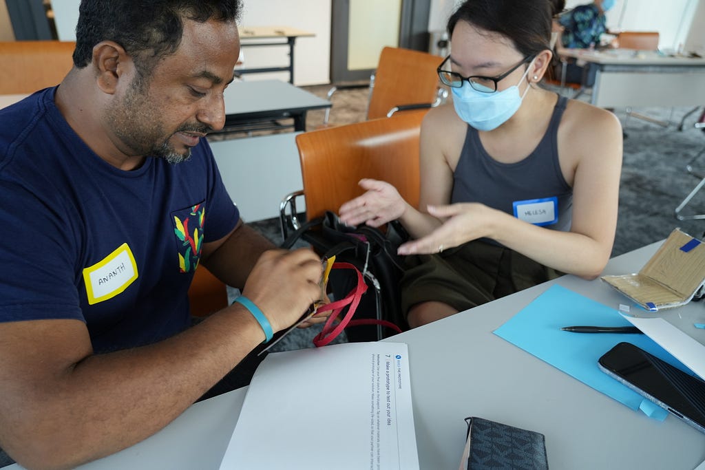 Woman explaining her wallet design to her workshop partner