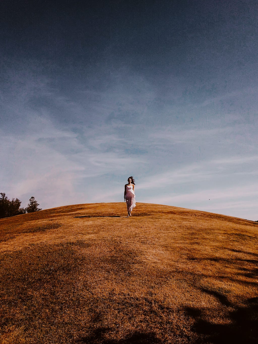 woman-standing-on-grass-hill
