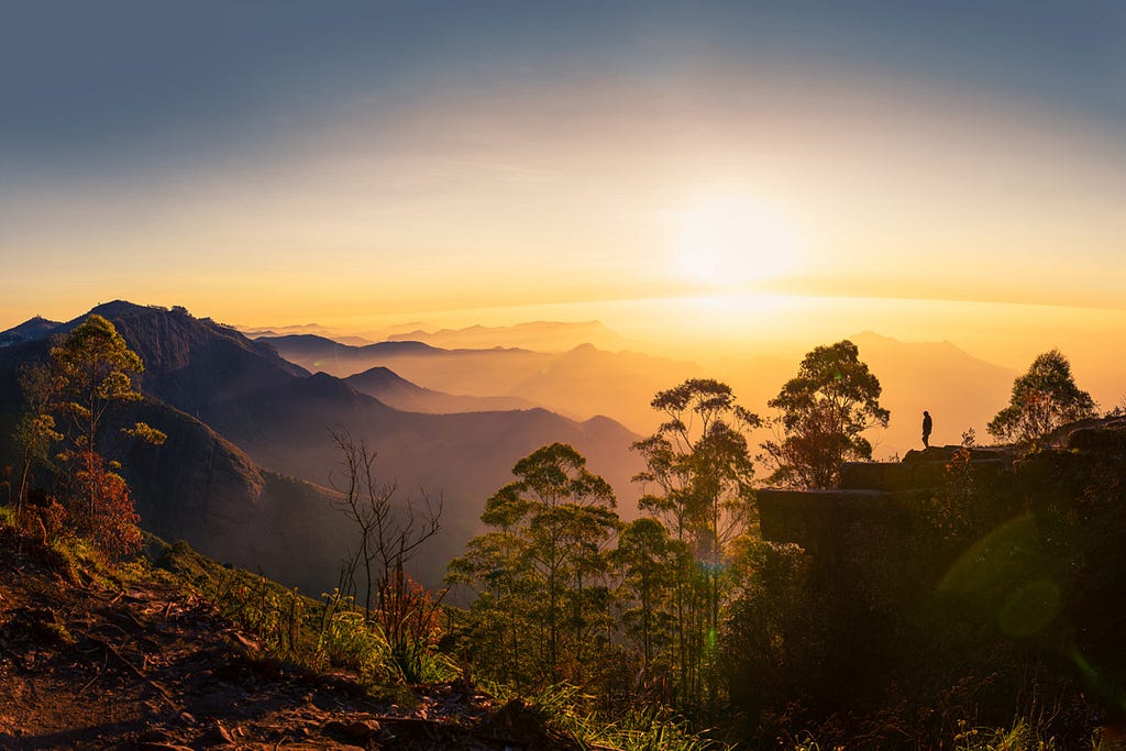 Silhouette of a woman watching the sunrise at Dolphin’s nose in Kodaikanal, Tamil Nadu.