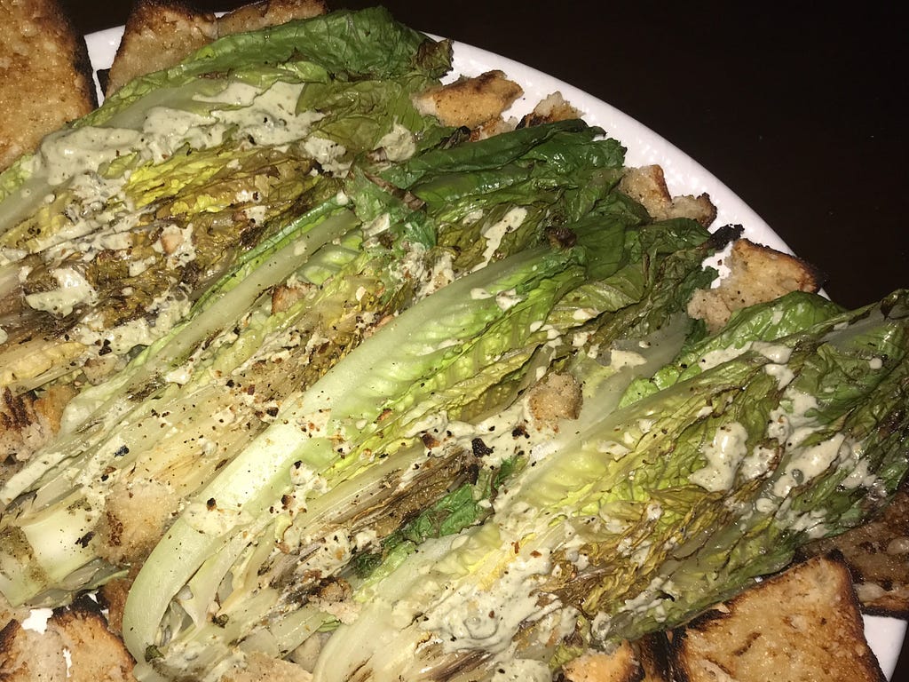 caesar dressing on a traditional wedge lettuce and crouton salad