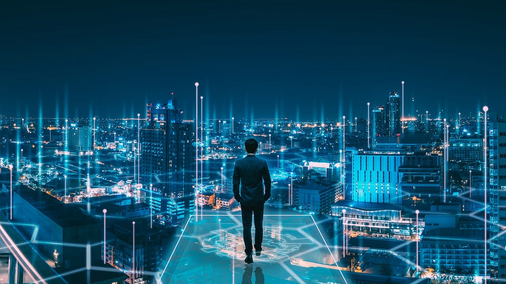 Uma pessoa em pé, em frente a um panorama de uma metrópole com gráficos de dados em volta dos prédios