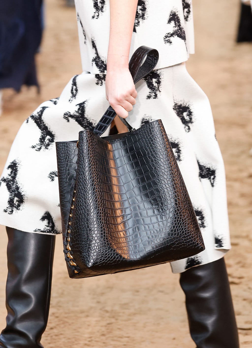 Model wears white and black horse print dress and black Frayme Tote Bag in AppleSkin™ on Stella McCartney Winter 2023 runway