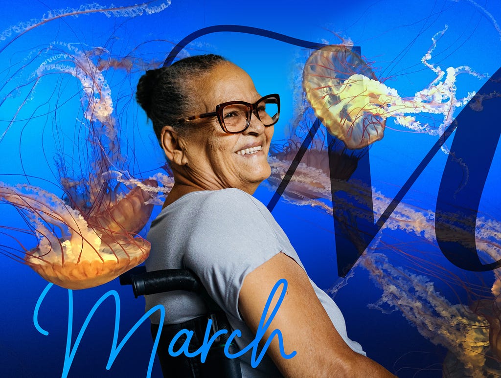 Positioned with the back of her right shoulder towards us, a Brown woman with glasses and wrinkles smiles while seated in a wheelchair. She is surrounded by an ocean of vibrant blue and yellow jellyfish in this photo collage. In the background there is a large M in cursive script, and in the foreground, the word March is written in a handwriting-like script.