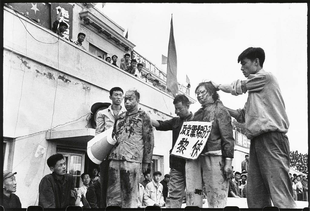 A photo from the Chinese Cultural Revolution, 1966, showing a Communist Party official and another official’s wife being publicly humiliated by young members of Mao’s Red Guard.