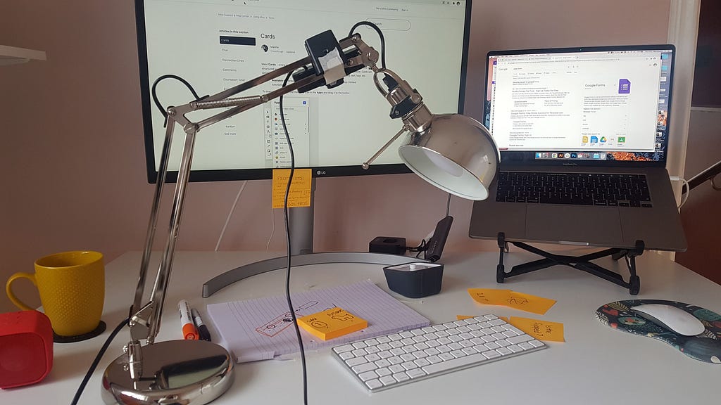 lamp on a table, with a web cam attached to its neck.