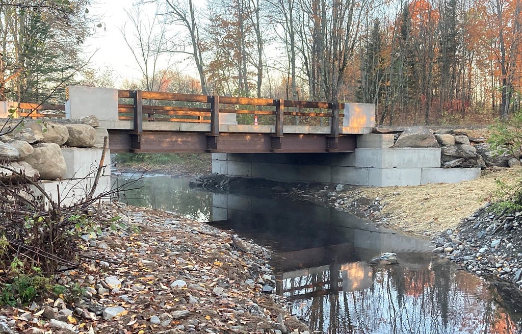 A bridge spans a stream with wide banks on each side