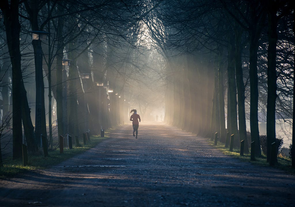 A woman running down an alley in autumn