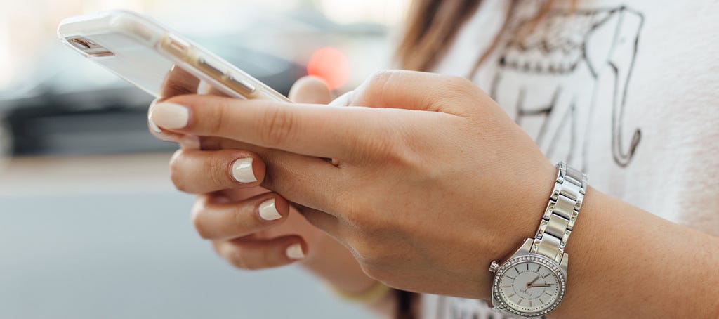 A woman’s hands interacting with a smartphone