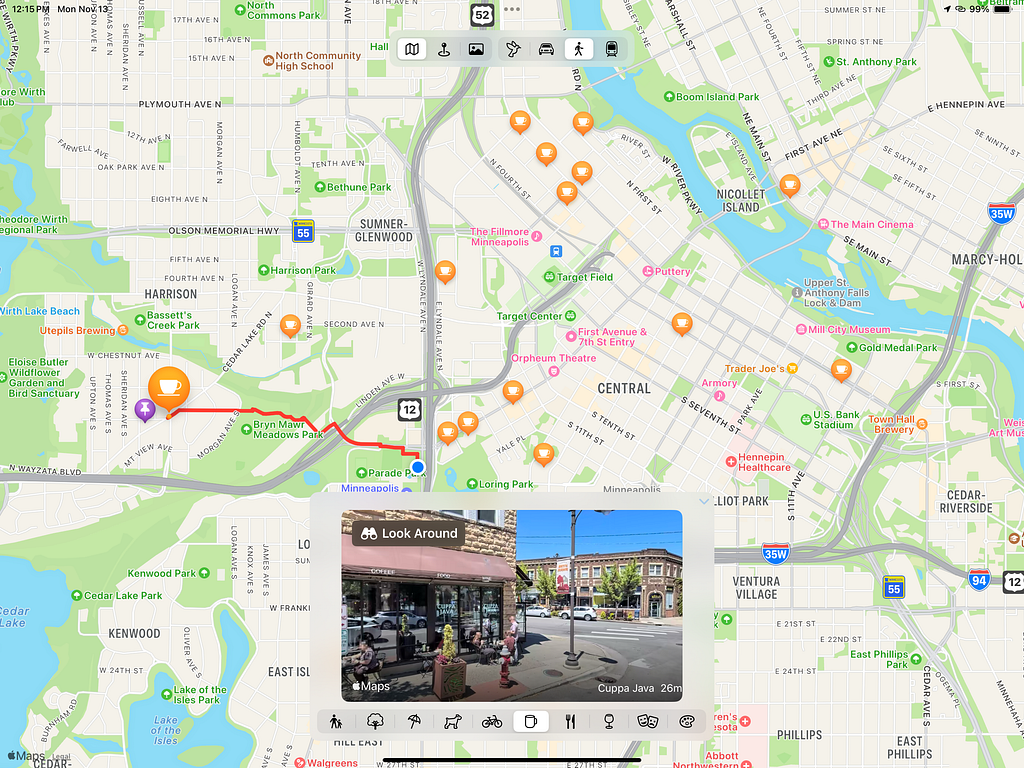 A screen shot of the TestMapReader app showing a Map View with the user’s location in Minneapolis. The Map has icons for all the cafés in the area. The Map shows where the user tapped with a purple pushpin and the café closest to the purple pushpin is enlarged and selected. The app presents a “Look Around” view of the selected café. The app has segmented pickers with icons for other selecting Map type, transit mode and search location type.