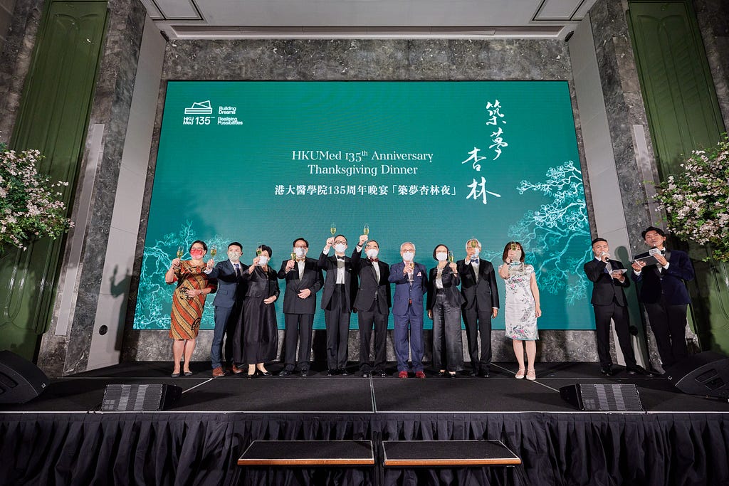 Event attendees on a stage toast with champagne