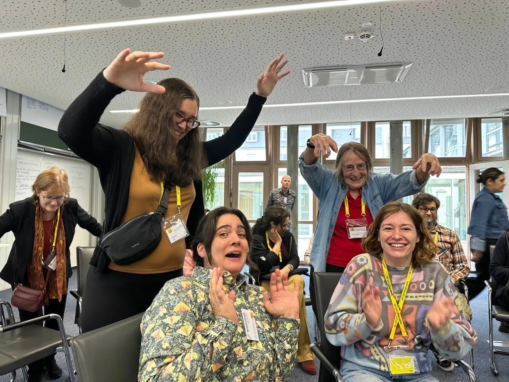 Amy and Mary with their arms stretched out over Cat and Olda, both cowering in fear.