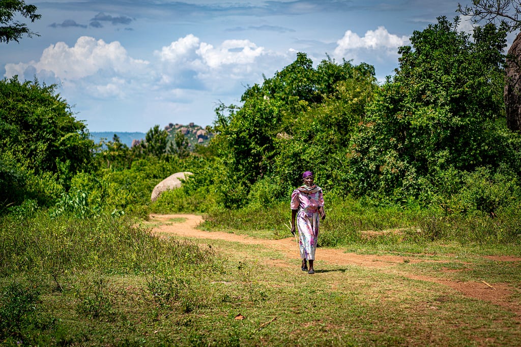 Woman walking on a dirt road.